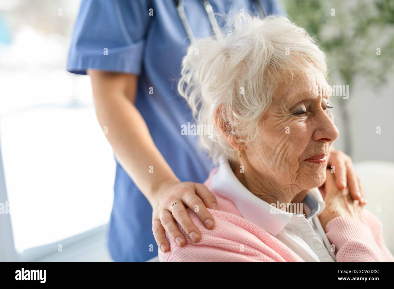Portrait d'une jeune infirmière médecin avec une patiente âgée à domicile lors d'une consultation Banque D'Images