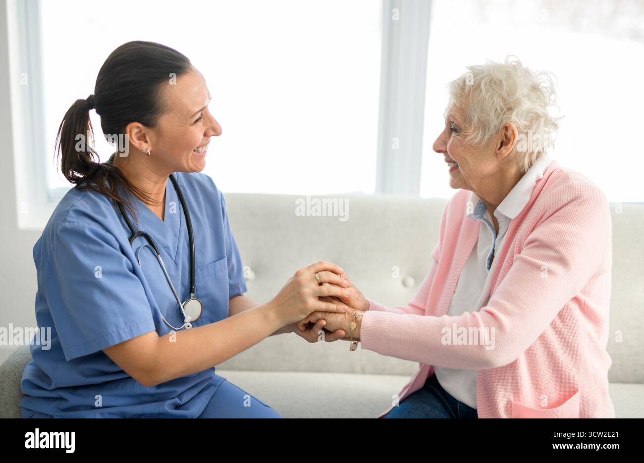 Portrait d'une jeune infirmière médecin avec une patiente âgée à domicile lors d'une consultation Banque D'Images