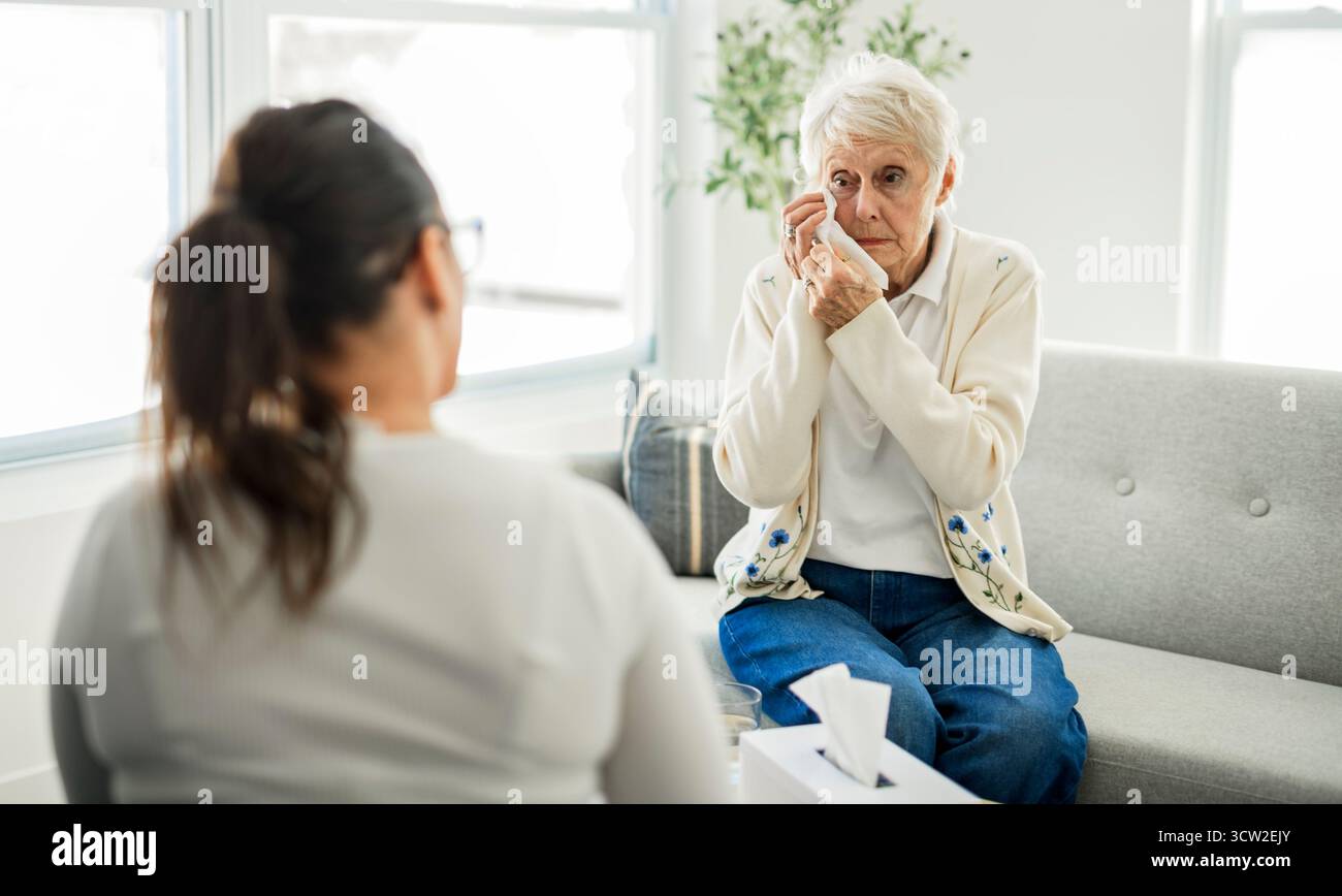 Une vieille femme pensant avec le psychologue dans le bureau de consultation pour l'esprit, l'évaluation ou l'évaluation. Banque D'Images