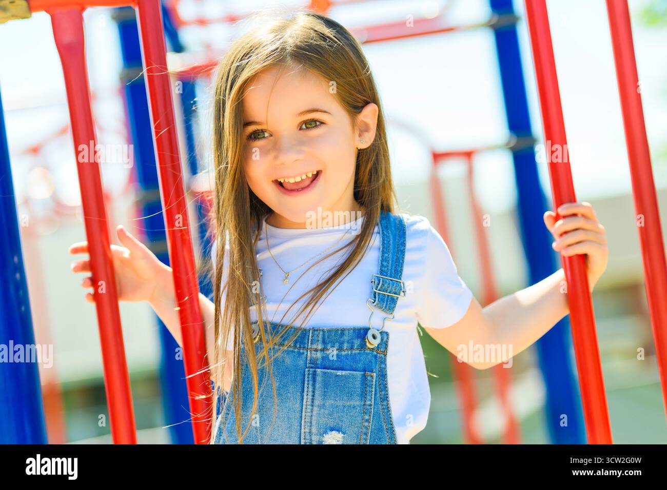 Une belle fille mignonne souriante sur une aire de jeux Banque D'Images