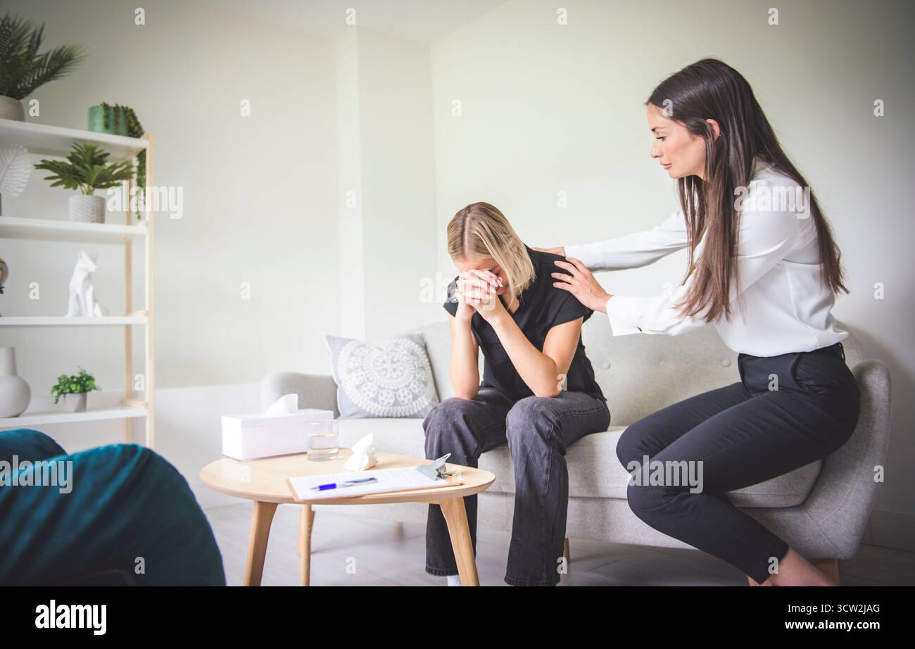 Un psychothérapeute soutenant une adolescente déprimée sur le canapé lors d'un rendez-vous au bureau un concept de psychothérapie Banque D'Images