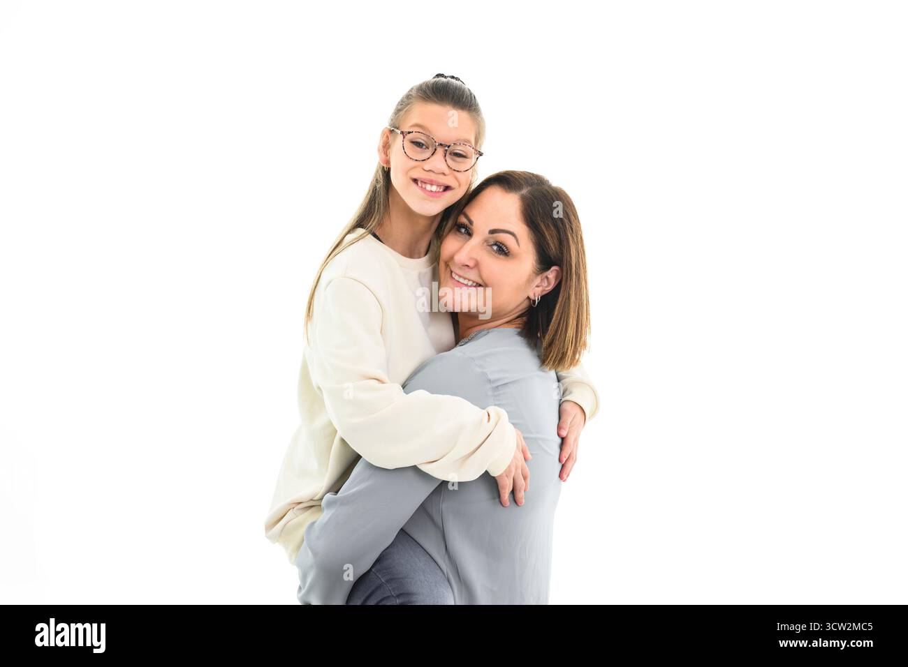 Un portrait d'une fille handicapée souriant à la caméra avec sa mère sur fond blanc Banque D'Images