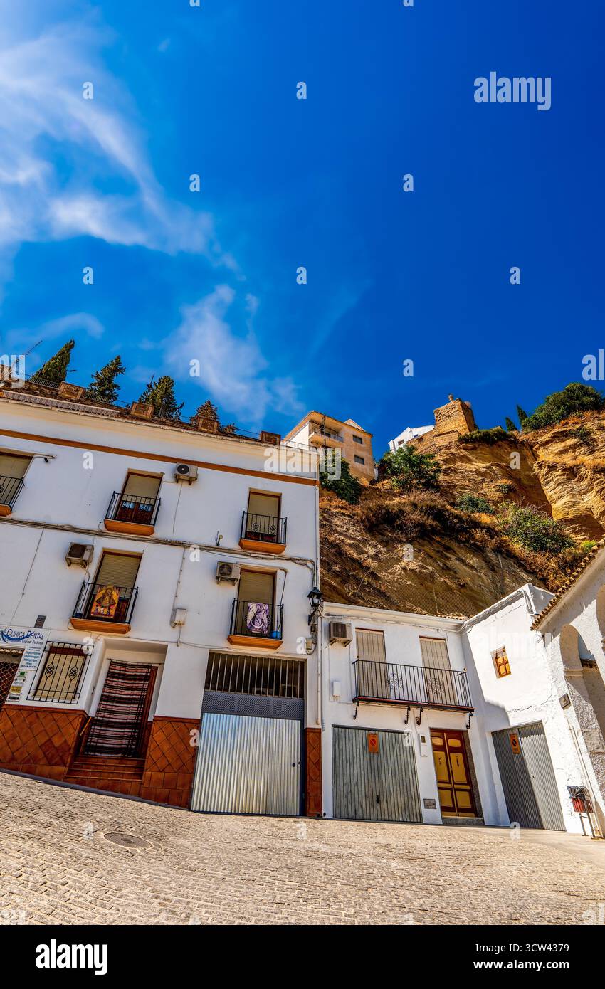 Maisons traditionnelles andalouses blanchies à la chaux construites sur une colline escarpée sous un ciel bleu vibrant dans le sud de l'Espagne Banque D'Images