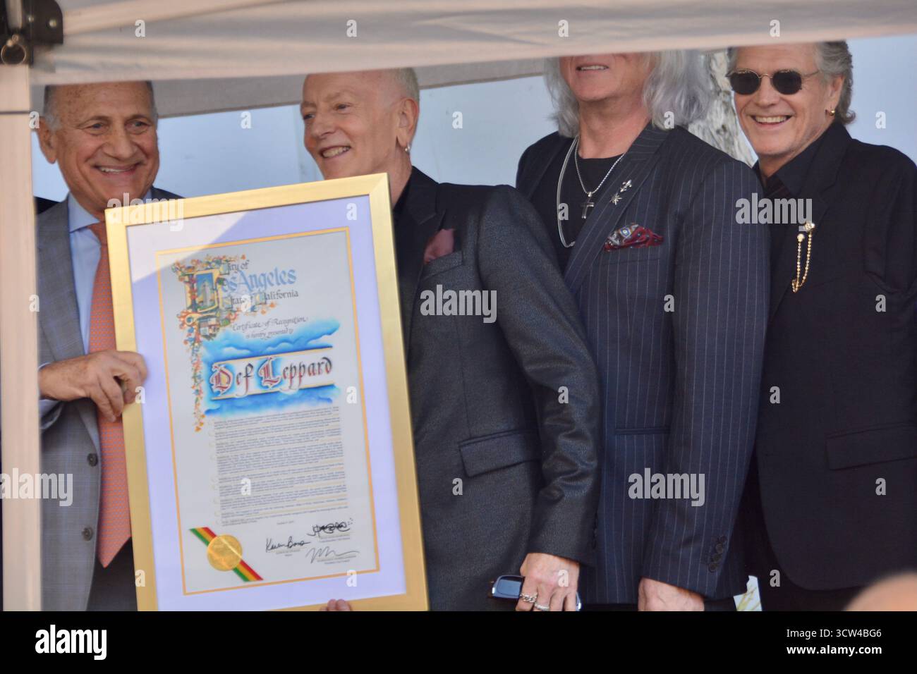 Steve Nissen, président de la Chambre de commerce d'Hollywood, présente une proclamation à DEF Leppard lors de la cérémonie des stars du Hollywood Walk of Fame, avec Phil Collen et Rick Allen en photo, le 9 octobre 2025, sur Vine Street devant le bâtiment Capitol Records à Los Angeles, en Californie. Banque D'Images Steve Nissen, président de la Chambre de commerce d'Hollywood, présente une proclamation à DEF Leppard lors de la cérémonie des stars du Hollywood Walk of Fame, avec Phil Collen et Rick Allen en photo, le 9 octobre 2025, sur Vine Street devant le bâtiment Capitol Records à Los Angeles, en Californie. Banque D'Images