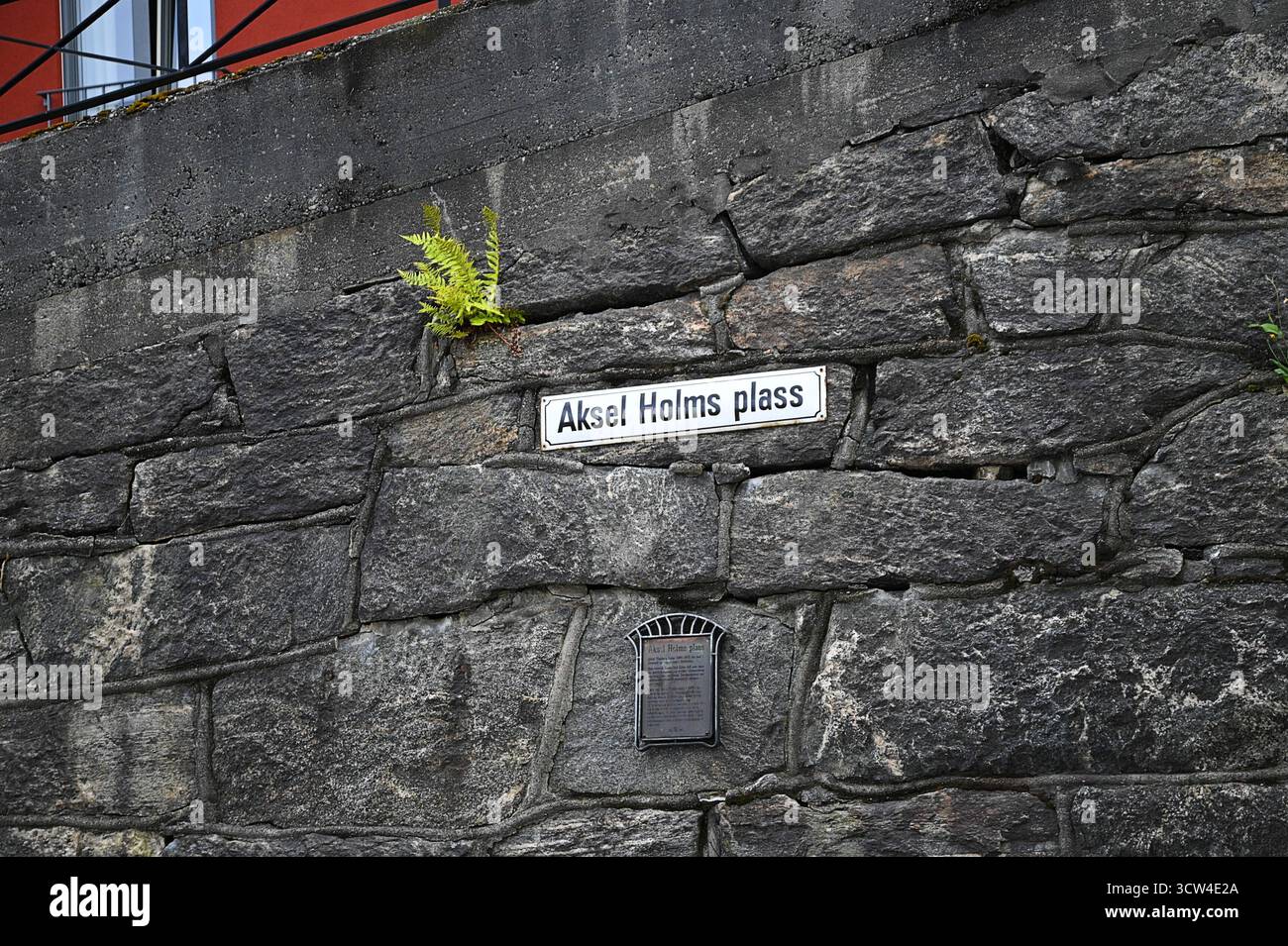 Panneau antique sur le mur de pierre d'Aksel Holms Plass une place publique de Ålesund dans l'ouest de la Norvège. Banque D'Images