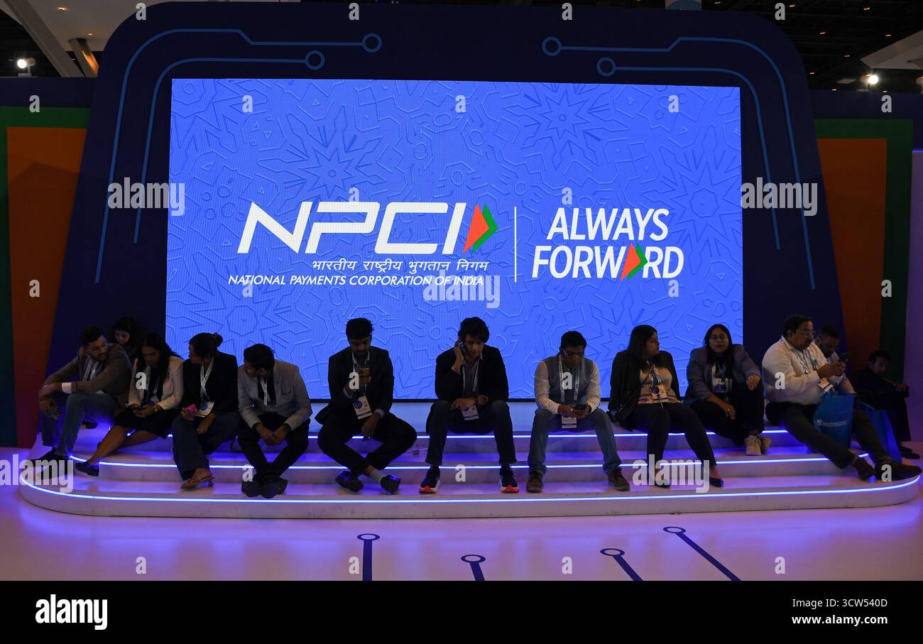 Les gens sont vus assis devant un écran LED affichant 'National Payments Corporation of India' (NPCI) le dernier jour du sixième Global Fintech Fest (GFF) à Mumbai. L’événement de trois jours qui s’est tenu du 7 au 9 octobre 2025, une plateforme mondiale pour encourager les principaux acteurs des firmes Fintech, qui se sont rassemblés pour partager et échanger des idées, et l’innovation dans les domaines bancaire, financier, de l’intelligence artificielle, des paiements numériques, des startups, et les nouvelles technologies se sont conclues le dernier jour avec le premier ministre indien Narendra Modi et le premier ministre britannique Keir Starmer s'adressant aux délégués présents à l'e Banque D'Images