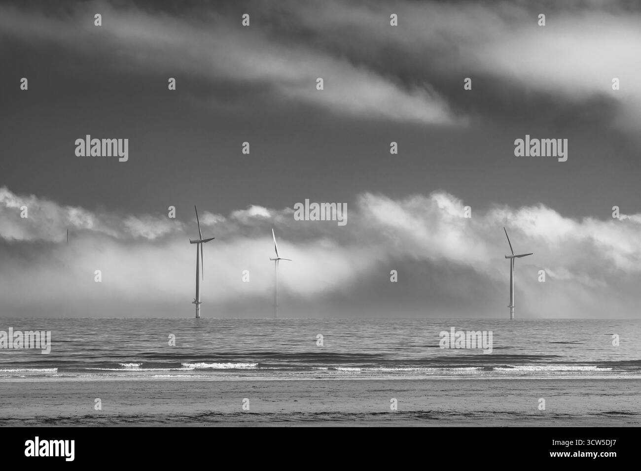 Éoliennes offshore en brouillard marin en noir et blanc Banque D'Images