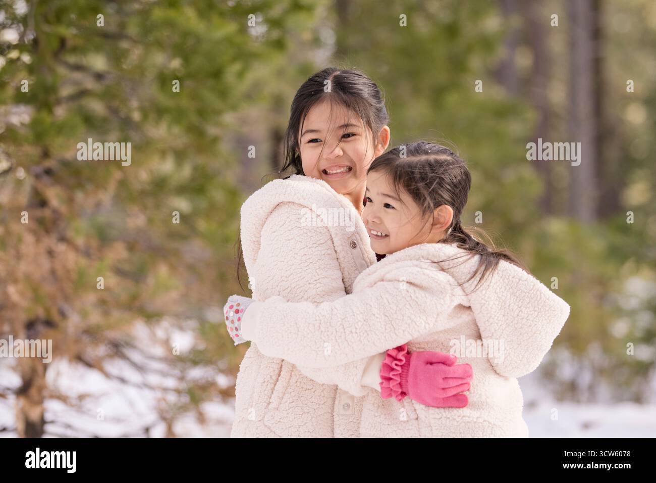 Deux filles souriantes et serrées dans la forêt Banque D'Images