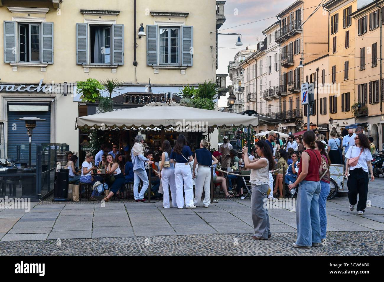Un bar extérieur bondé de gens à l'heure de l'apéritif, sur la Piazza del Carmine, quartier historique de Brera, au printemps, Milan, Lombardie, Italie Banque D'Images