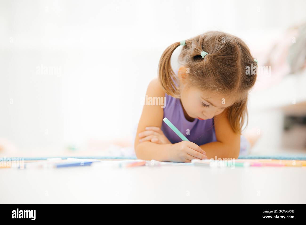 Une jeune fille pleinement engagée dans une activité de dessin créative et amusante qui stimule son imagination Banque D'Images