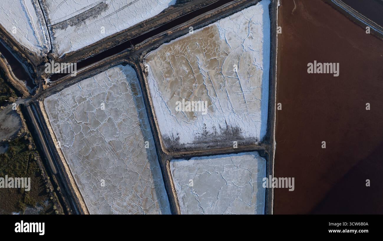 Vue aérienne d'étangs salés géométriques reflétant le ciel dans les tons de blanc, gris et brun, créant un paysage de mosaïque texturée, Sunnyvale, Californie, États-Unis. Banque D'Images