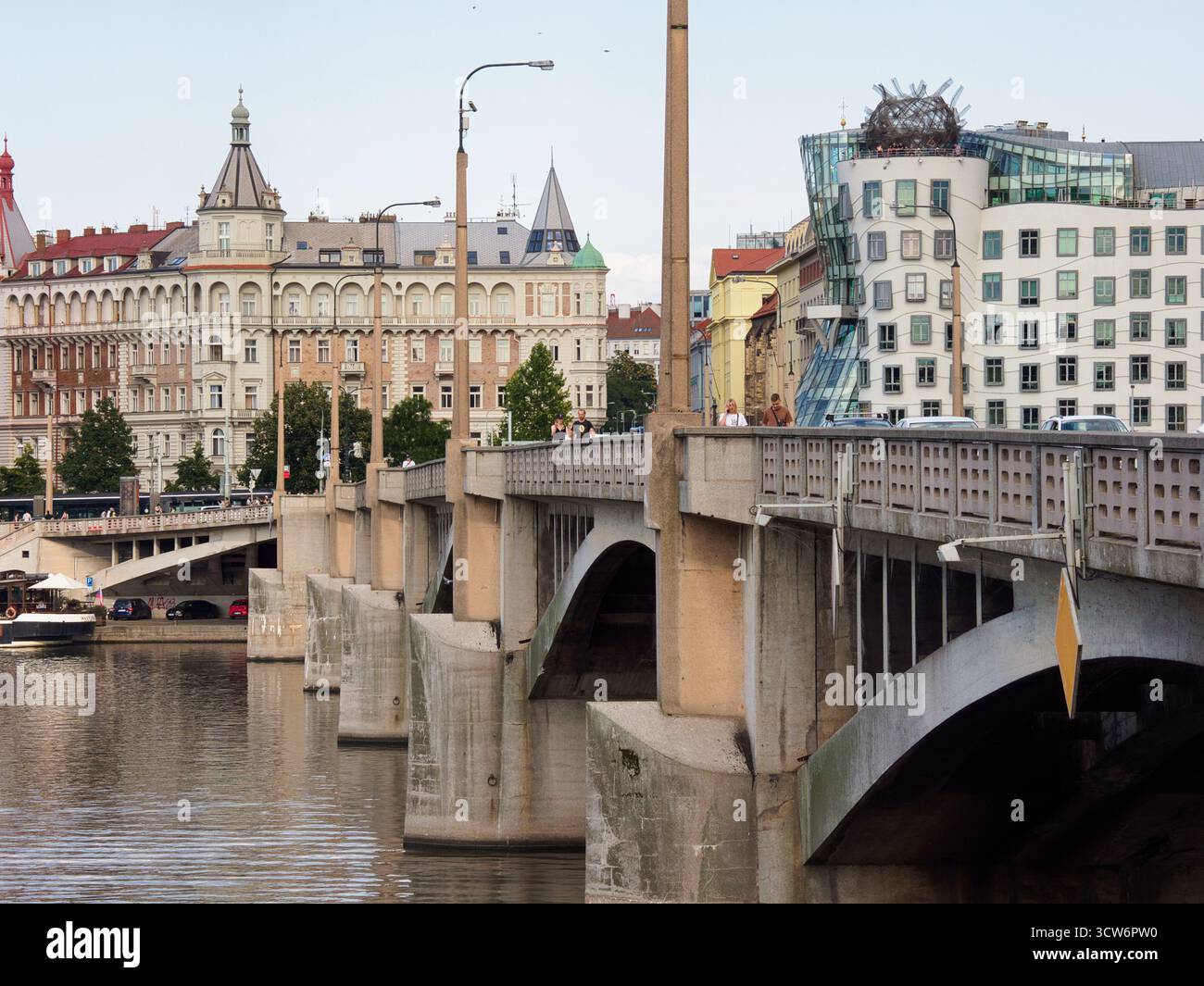 Prague Bridge View of Dancing House & Vltava - scène urbaine montrant un pont et le contraste entre l'architecture historique et déconstructiviste le long Banque D'Images