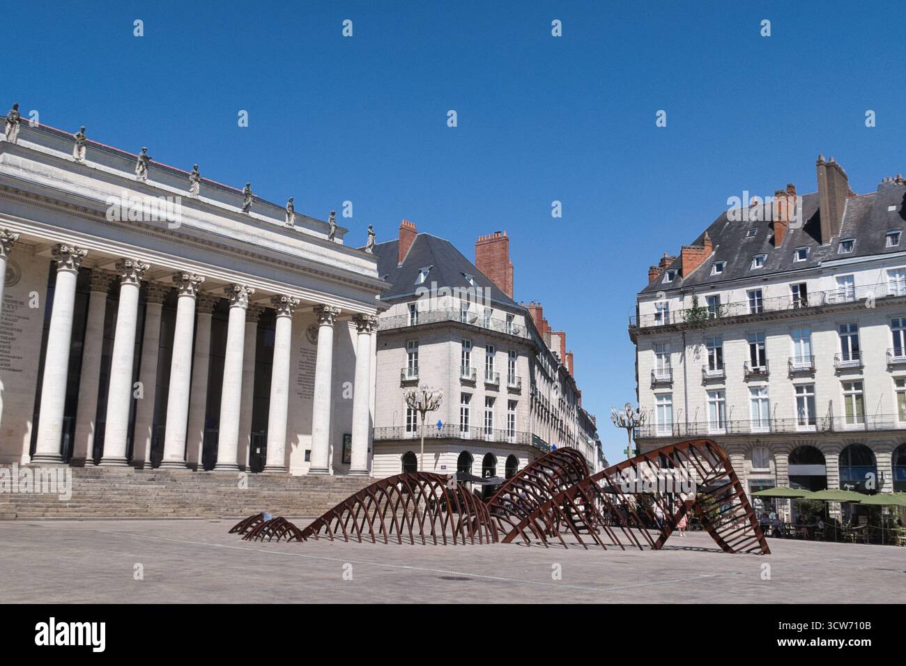 Théâtre de Nantes et sculpture de serpent - néoclassique Théâtre Graslin à Nantes, France, avec sculpture moderne en métal d'un serpent/cage thoracique sur les pavés Banque D'Images