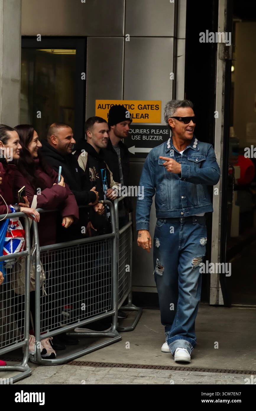 Londres, Royaume-Uni, 10 octobre 2025. Robbie Williams quitte la BBC et prend des vidéos avec des fans après être apparu sur BBC Radio 1 Live Lounge. Crédit : Ben Shaw/Alamy Live News Banque D'Images