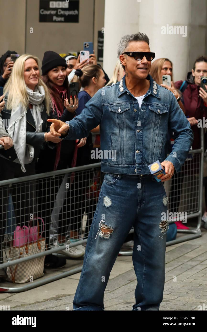 Londres, Royaume-Uni, 10 octobre 2025. Robbie Williams quitte la BBC et prend des vidéos avec des fans après être apparu sur BBC Radio 1 Live Lounge. Crédit : Ben Shaw/Alamy Live News Banque D'Images