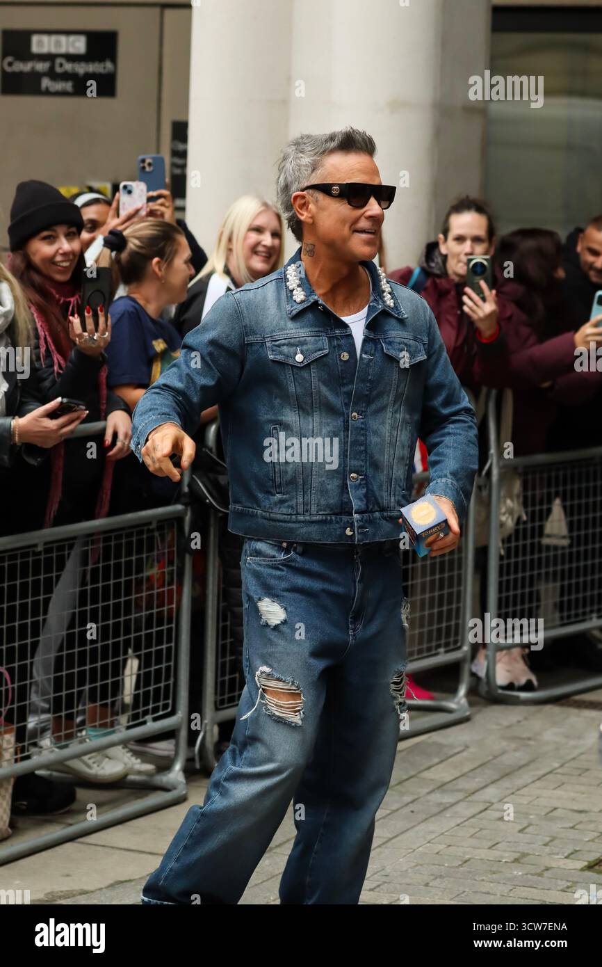 Londres, Royaume-Uni, 10 octobre 2025. Robbie Williams quitte la BBC et prend des vidéos avec des fans après être apparu sur BBC Radio 1 Live Lounge. Crédit : Ben Shaw/Alamy Live News Banque D'Images