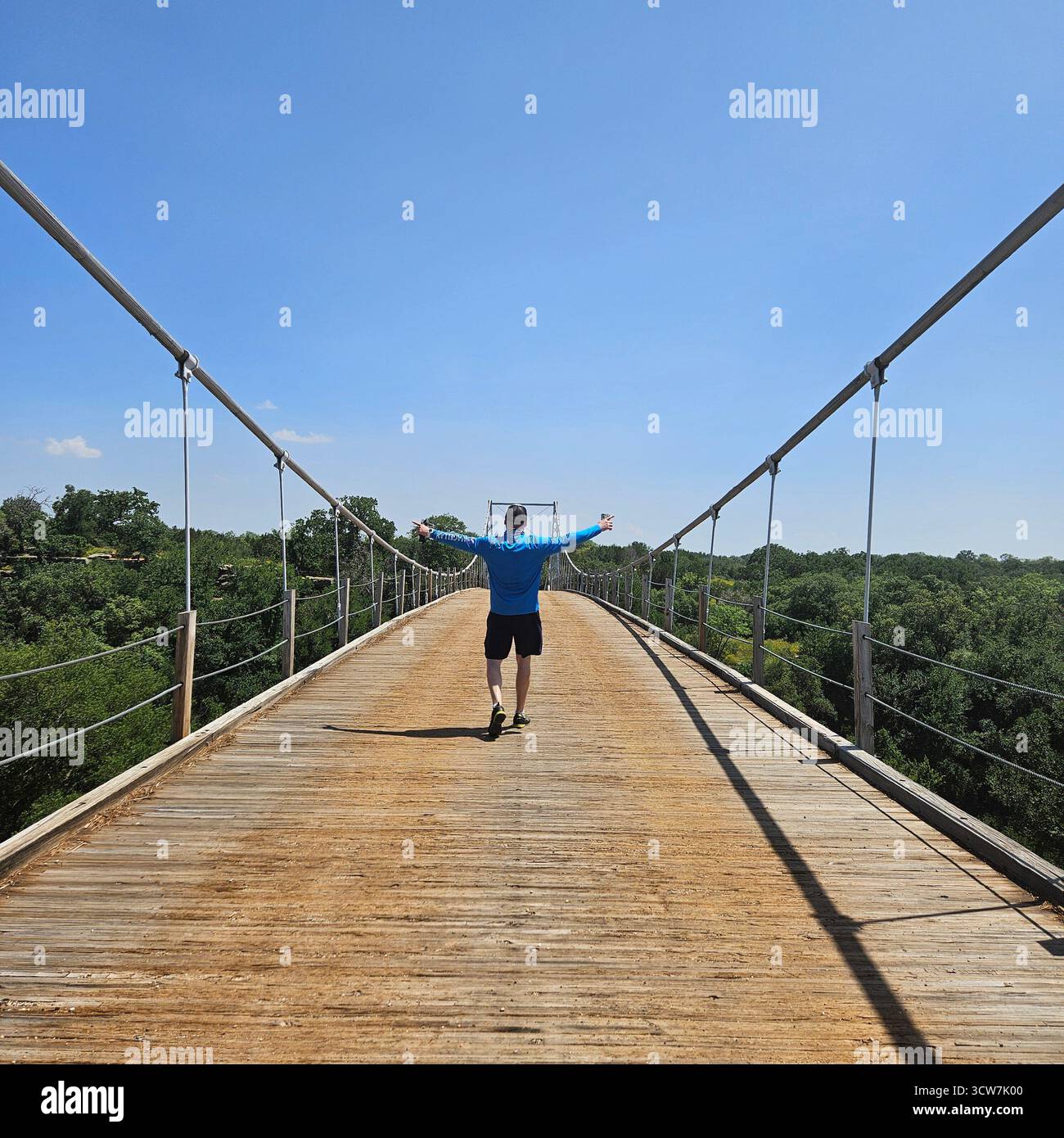 Un homme marche sur un vieux pont suspendu à Regency, Texas Banque D'Images