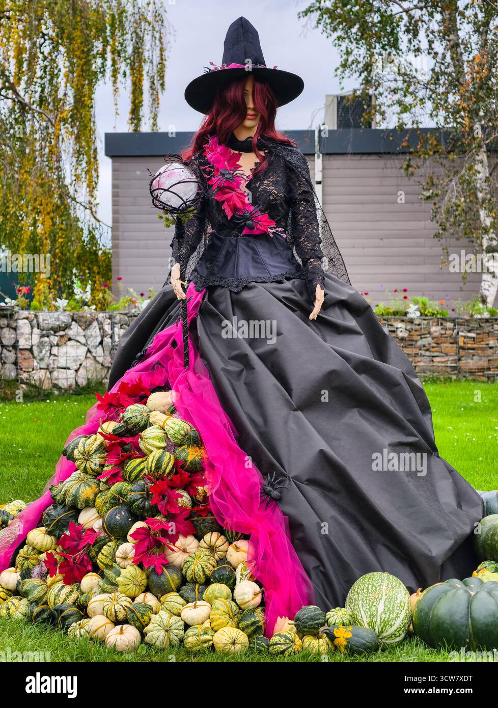 Halloween Witch costume femme en robe noire avec citrouilles Fall Leaves Autumn Garden Party décoration Fantasy personnage Portrait. Fond d'écran nature Banque D'Images