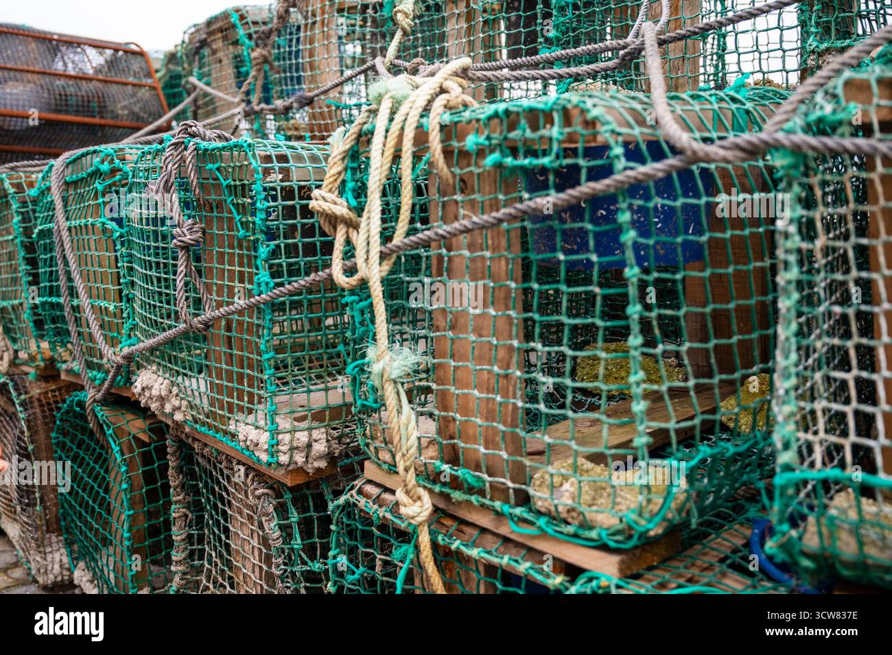 Un tas de cages de pêche avec des cordes suspendues. La scène est quelque peu chaotique et désorganisée Banque D'Images