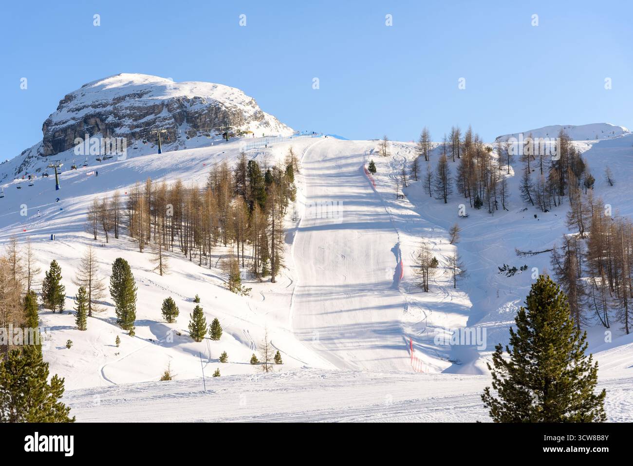 Piste de ski déserte dans une station de montagne dans les Alpes par une journée ensoleillée d'hiver Banque D'Images