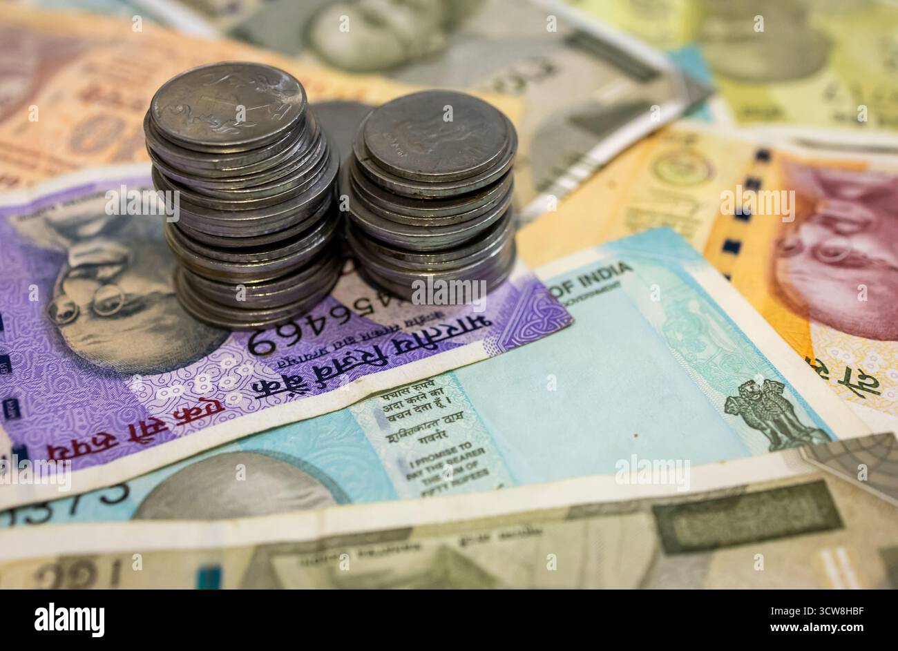 Pièces empilées sur des billets de banque en roupie indienne Banque D'Images