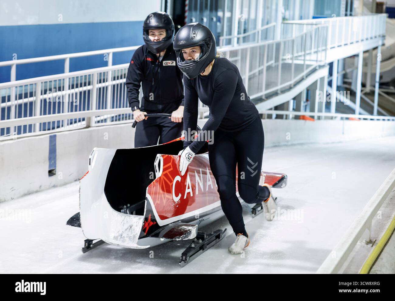 Calgary, Canada. 10 octobre 2025. Kelsey Mitchell, à droite, médaillée d’or olympique en cyclisme sur piste, et la pilote Bianca Ribi repoussent leur traîneau au départ alors que Mitchell s’essaye pour l’équipe canadienne de bobsleigh à Calgary, Alta., vendredi 10 octobre 2025. Crédit : la presse canadienne/Alamy Live News Banque D'Images