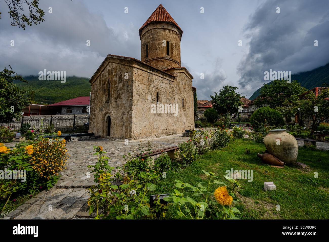 L'ancienne église albanaise de Kish entourée d'un jardin avec des fleurs et des pots d'argile dans le village de Kish près de Shaki, Azerbaïdjan. Ce chrétien primitif Banque D'Images