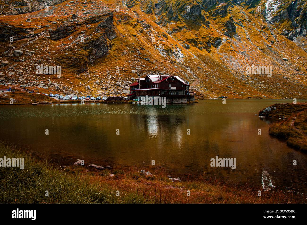 Pittoresque Mountain Lodge au lac Balea reflété dans l'eau, montagnes Fagaras, automne Banque D'Images