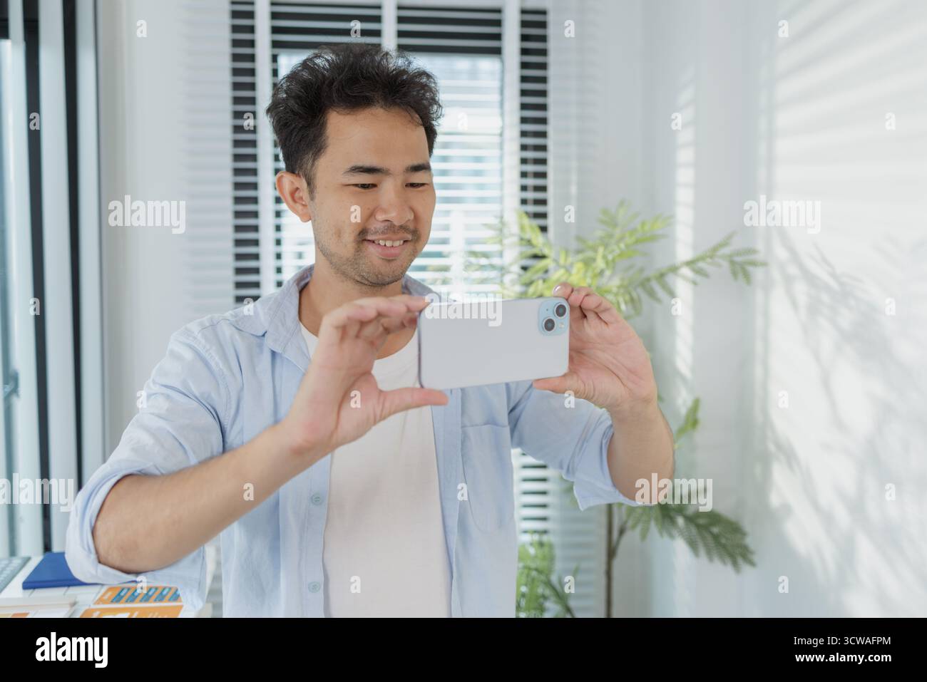 Un concepteur créatif travaille sur la planification UX/UI, analysant des croquis et des prototypes sur un tableau blanc tout en utilisant un ordinateur portable. Le processus montre la pensée de conception Banque D'Images