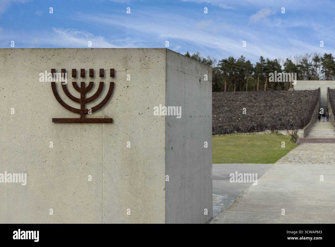 Belzec, Pologne - 29 avril 2025 : Musée et Mémorial à Belzec, camp d'extermination nazi. Mur avec menorah de fer et Death Road (crevasse) throu Banque D'Images