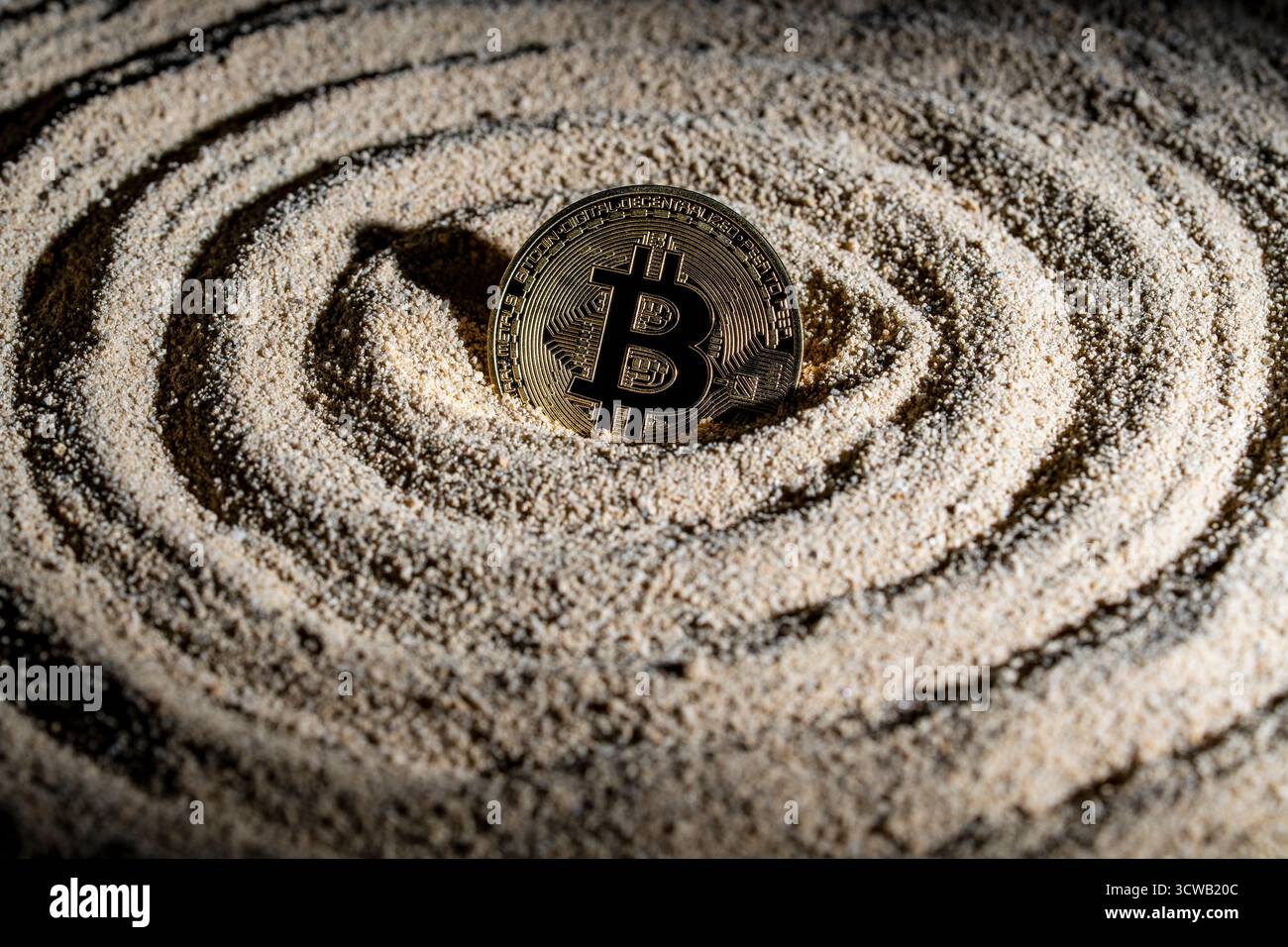 Pièce d'or bitcoin, rayon de soleil et cercles dans le sable, gros plan. Concept sur la méditation d'argent de crypto-monnaie Banque D'Images