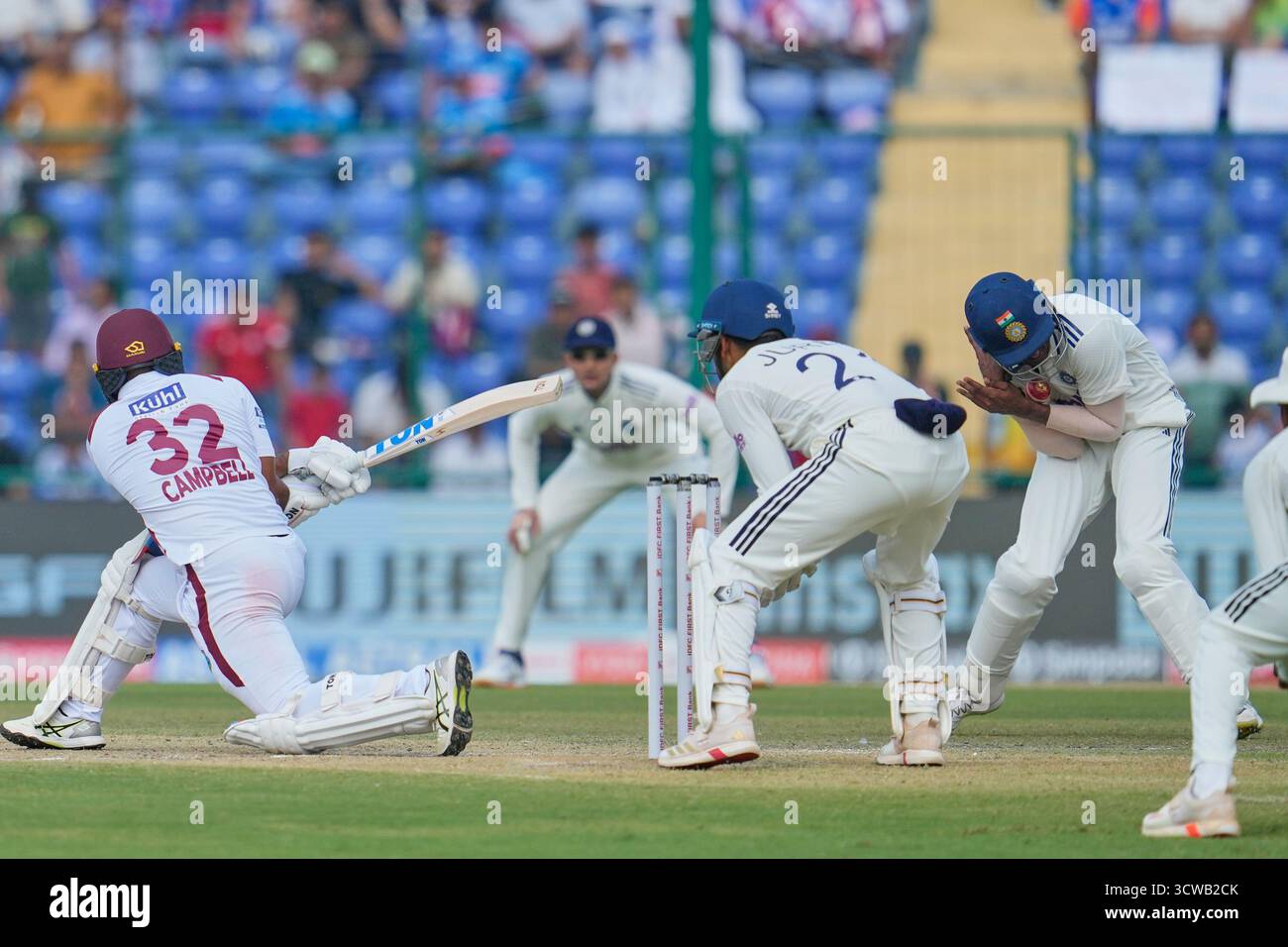 India's Sai Sudharsan, right, reacts in pain after taking the catch of West Indies' John Campbell, left, hurting his little finger on the second day of the second cricket test match between India and West Indies at the Arun Jaitley Stadium in New Delhi, India, Saturday, Oct.11, 2025. (AP Photo/Manish Swarup) Banque D'Images