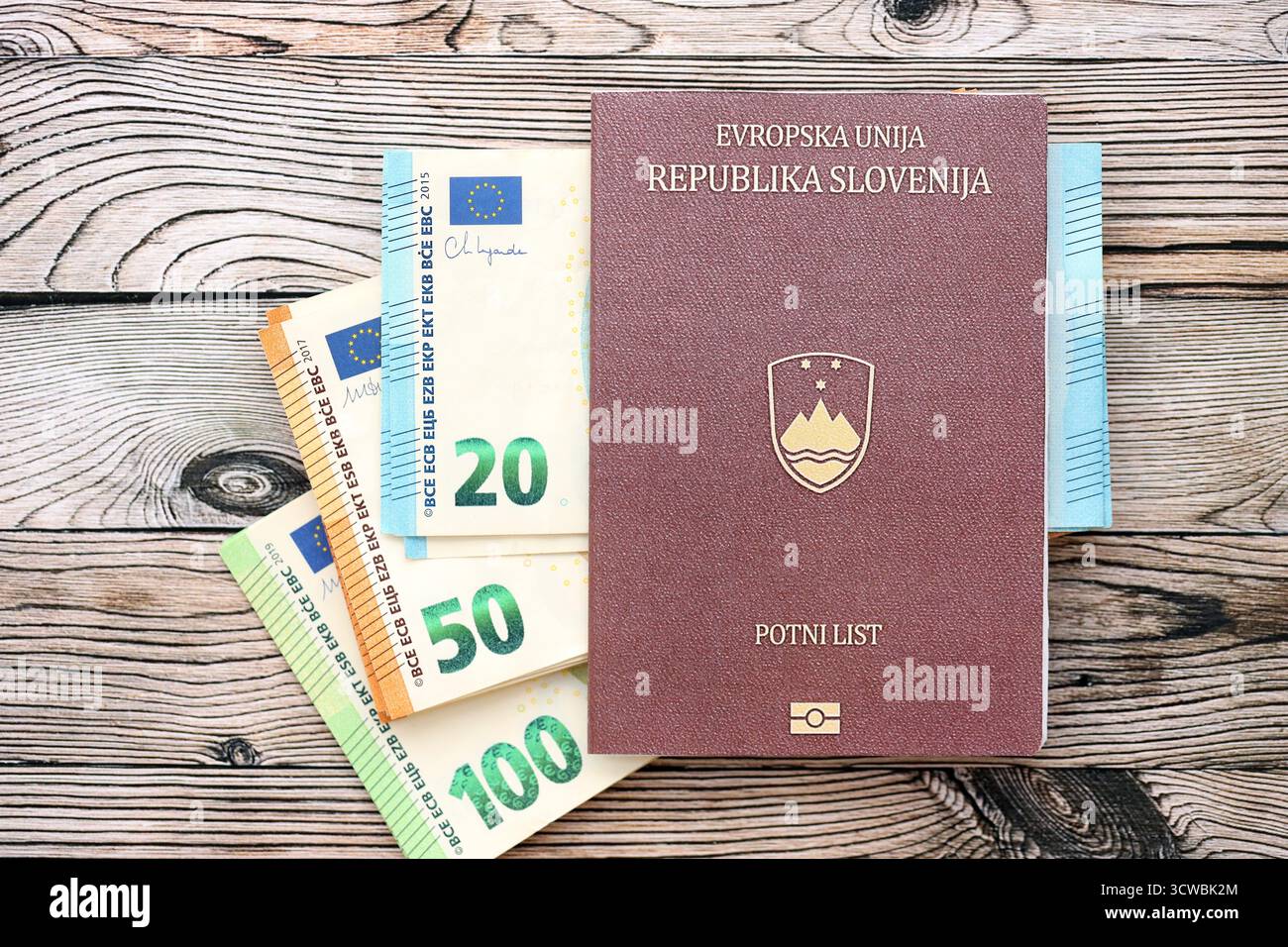 Passeport slovène se trouve avec des billets de banque en euros sur fond de bois gros plan. Espèces et paiements en Europe concept Banque D'Images