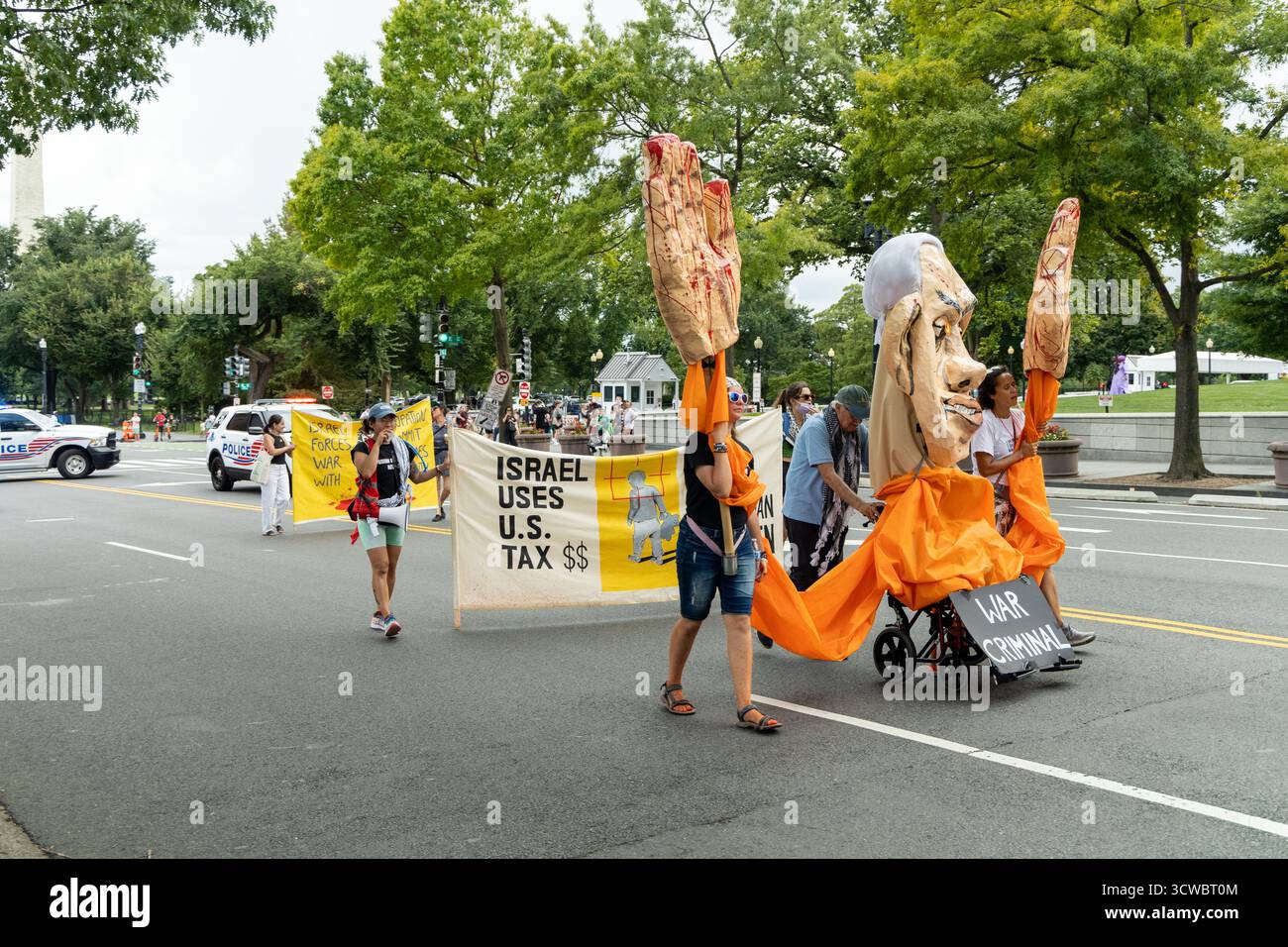 Washington DC, États-Unis - 19/2024 : un groupe de personnes défilent dans la rue avec des pancartes disant "Israël utilise les dollars des impôts américains pour opprimer les Palestiniens Banque D'Images Washington DC, États-Unis - 19/2024 : un groupe de personnes défilent dans la rue avec des pancartes disant "Israël utilise les dollars des impôts américains pour opprimer les Palestiniens Banque D'Images