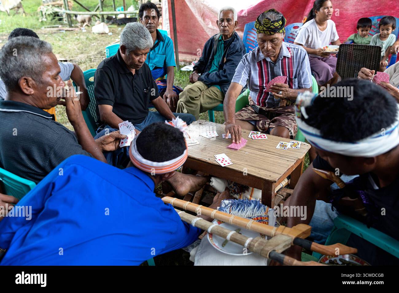 Des gens jouent aux cartes en attendant des funérailles sur l'île de sumba en indonésie Banque D'Images