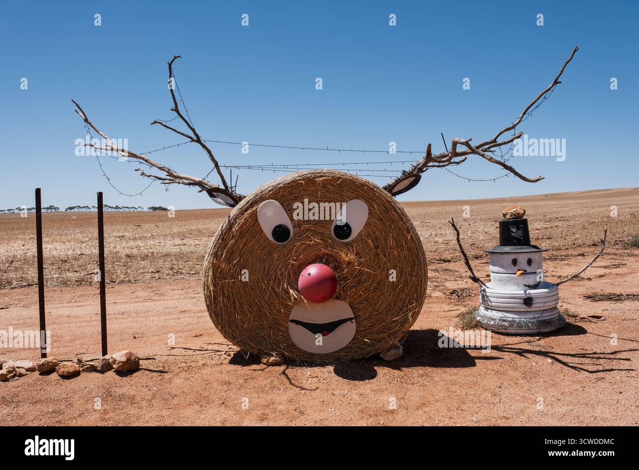 Décorations de Noël d'un fermier dans la ceinture australienne de blé - un renne fait d'un rouleau de paille et bonhomme de neige fait de vieux pneus, Kondinin, WA Banque D'Images