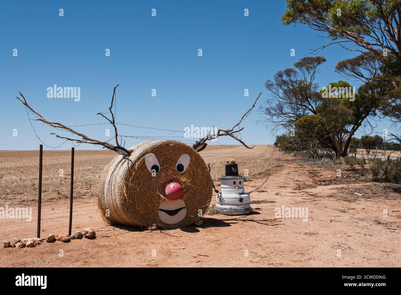 Décorations de Noël d'un fermier dans la ceinture australienne de blé - un renne fait d'un rouleau de paille et bonhomme de neige fait de vieux pneus, Kondinin, WA Banque D'Images