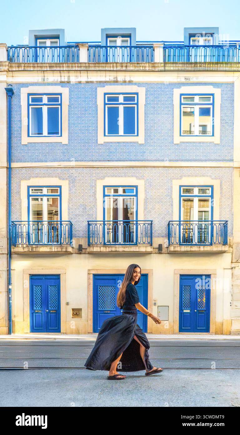 Mulher a caminhar junto a Edifício tradicional com portas azuis, Lisboa, Portugal Banque D'Images