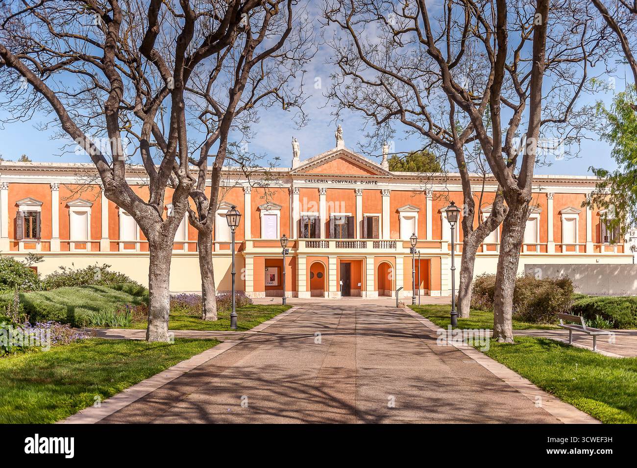Galerie civique d'Art moderne à Cagliari, Sardaigne, Italie, façade néoclassique encadrée par des arbres et la lumière du soleil dans un parc public Banque D'Images