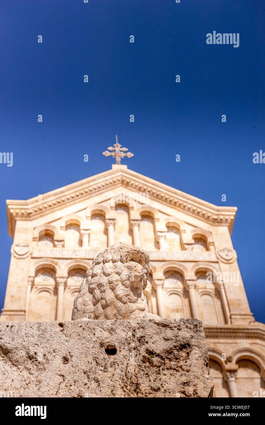 Façade de la cathédrale de Cagliari en Sardaigne, Italie, avec sculpture de lion en pierre au premier plan sous un ciel bleu profond Banque D'Images