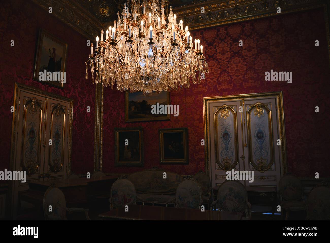Paris France 1 juin 2025 lustre et murs rouges dans le salon royal du Louvre Banque D'Images