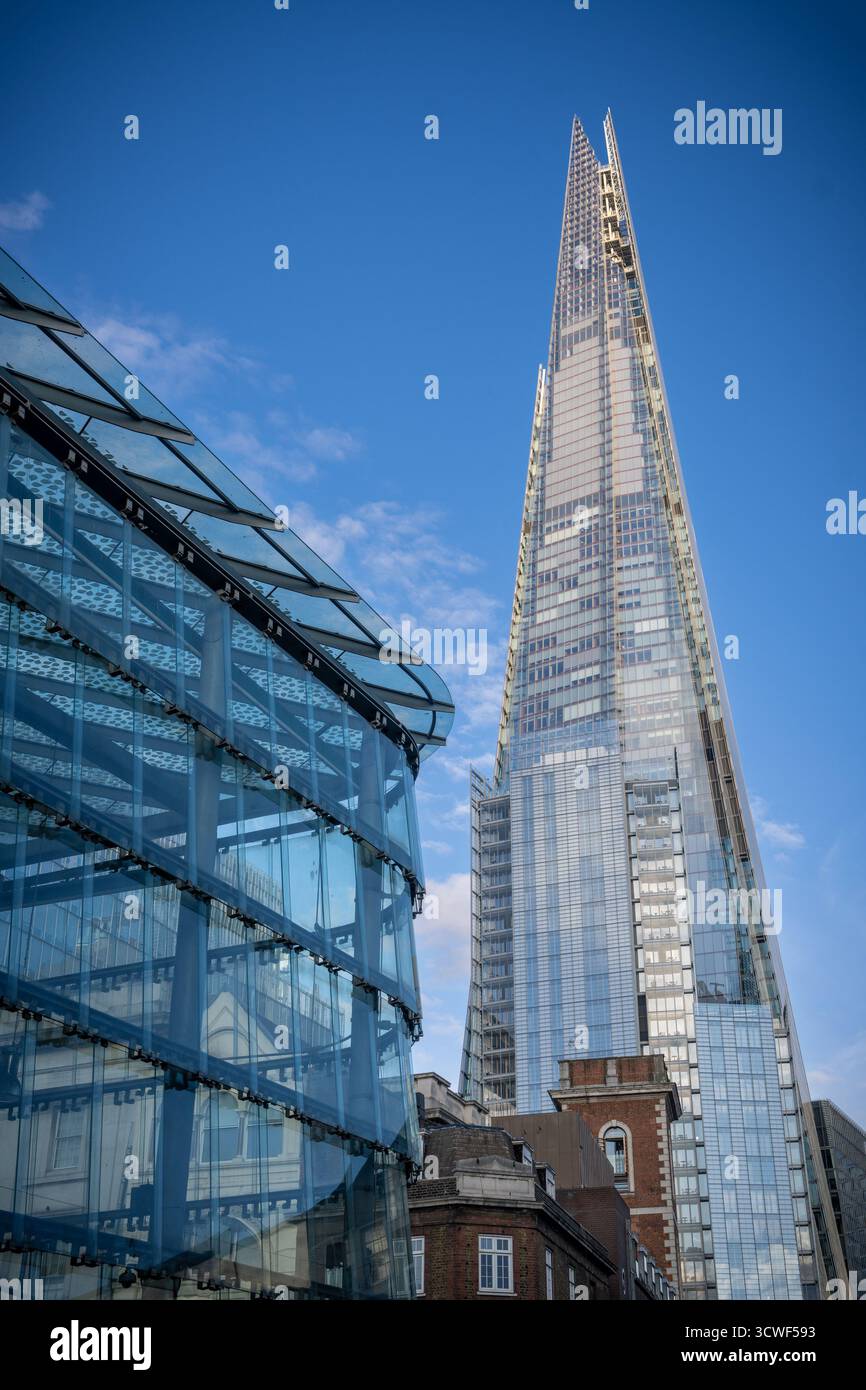 Vue sur The Shard, le gratte-ciel emblématique de Londres, contre un ciel bleu clair par une journée ensoleillée, mettant en valeur son architecture vitrée moderne. Banque D'Images