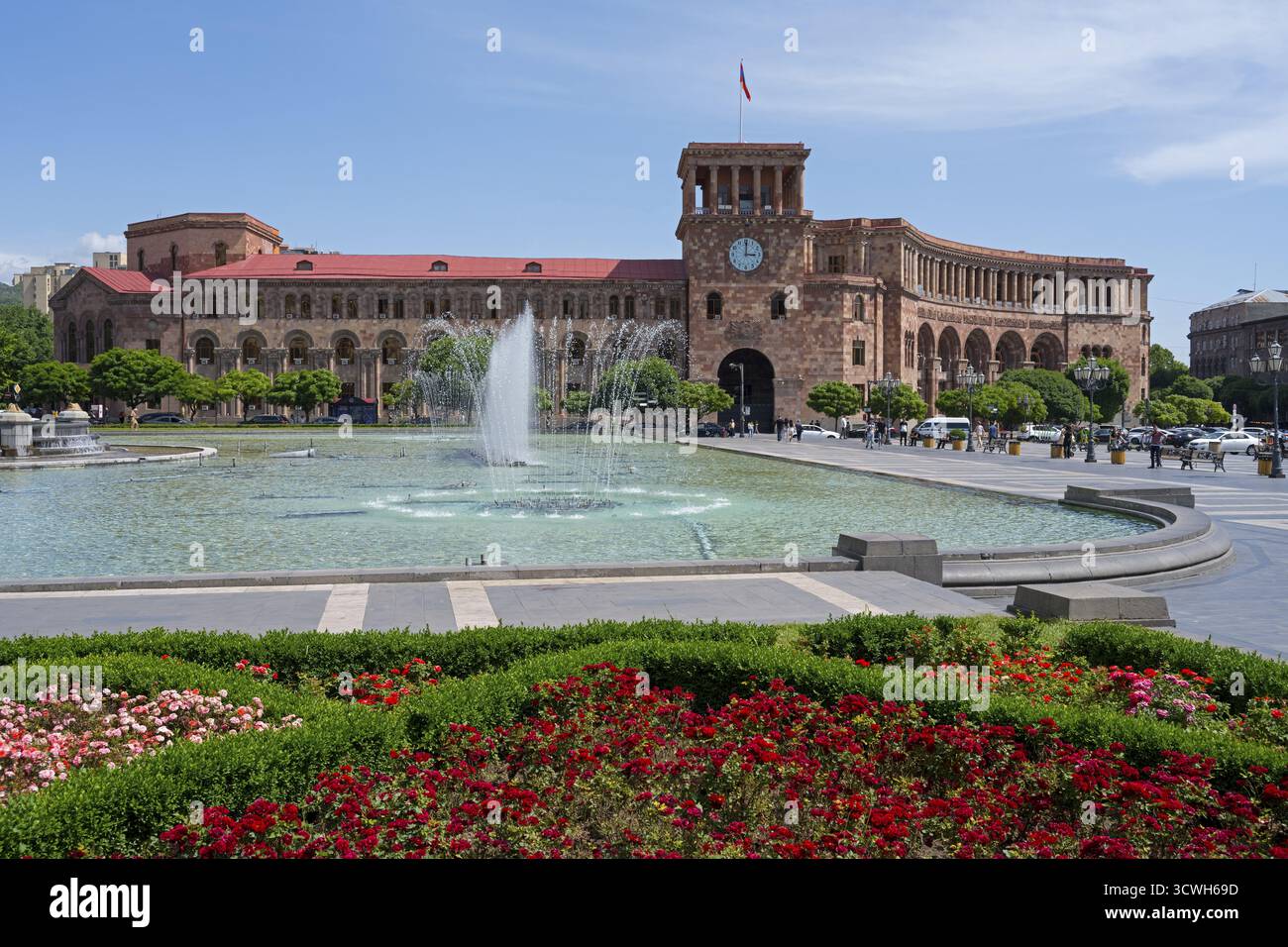 Grande place avec fontaine, entourée de parterres de fleurs et un bâtiment historique avec horloge, Palais du gouvernement sur la place de la République, Erevan, Erevan, arme Banque D'Images