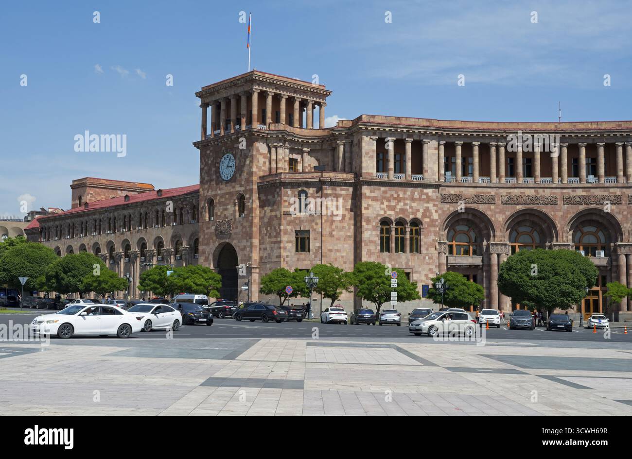 Bâtiment historique avec tour de l'horloge et des arches, voitures passant sur une place, Palais du Gouvernement sur la place de la République, Erevan, Erevan, Arménie Banque D'Images