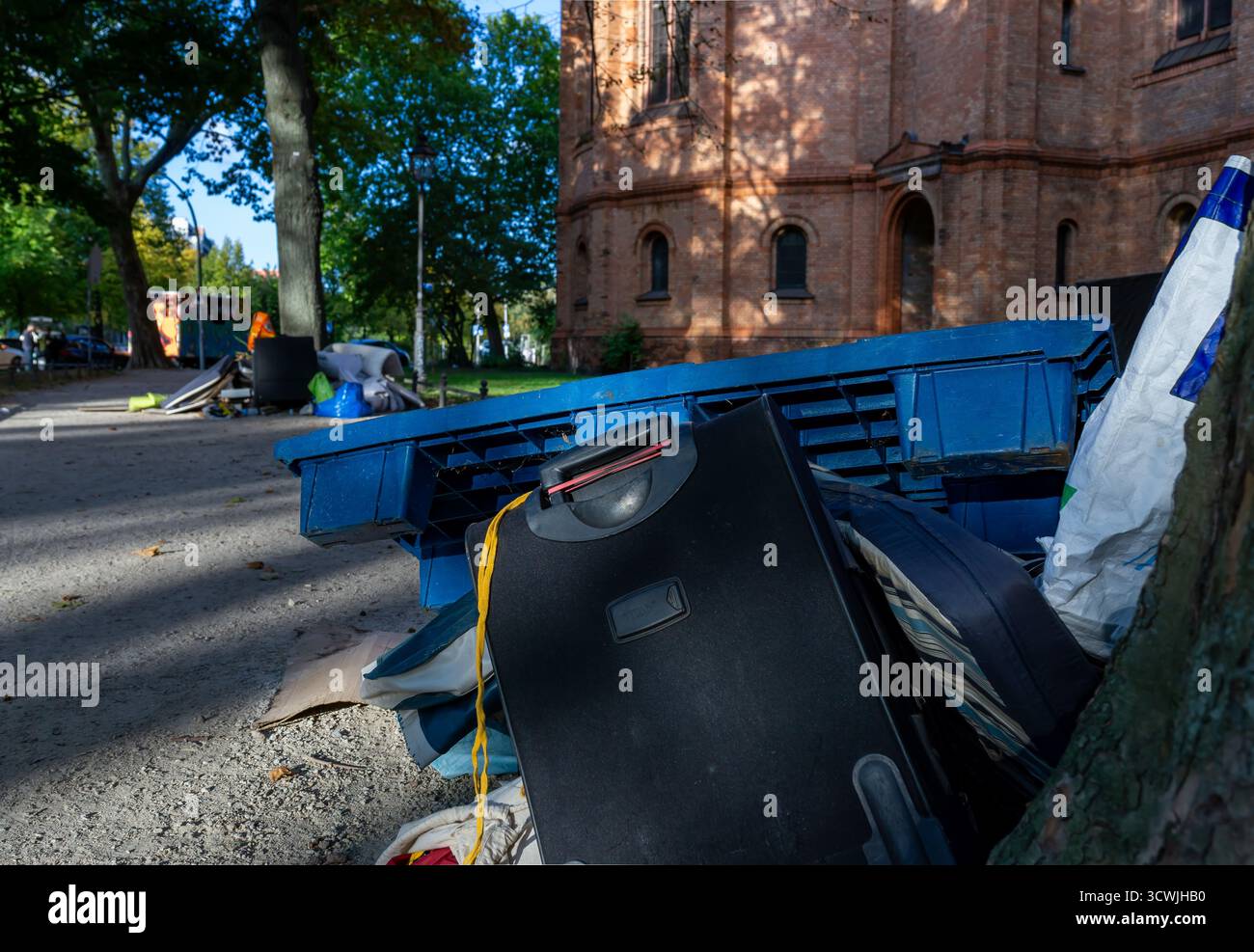 Tas d'ordures et meubles jetés devant une église historique de Kreuzberg, Berlin, symbolisant la négligence urbaine Banque D'Images