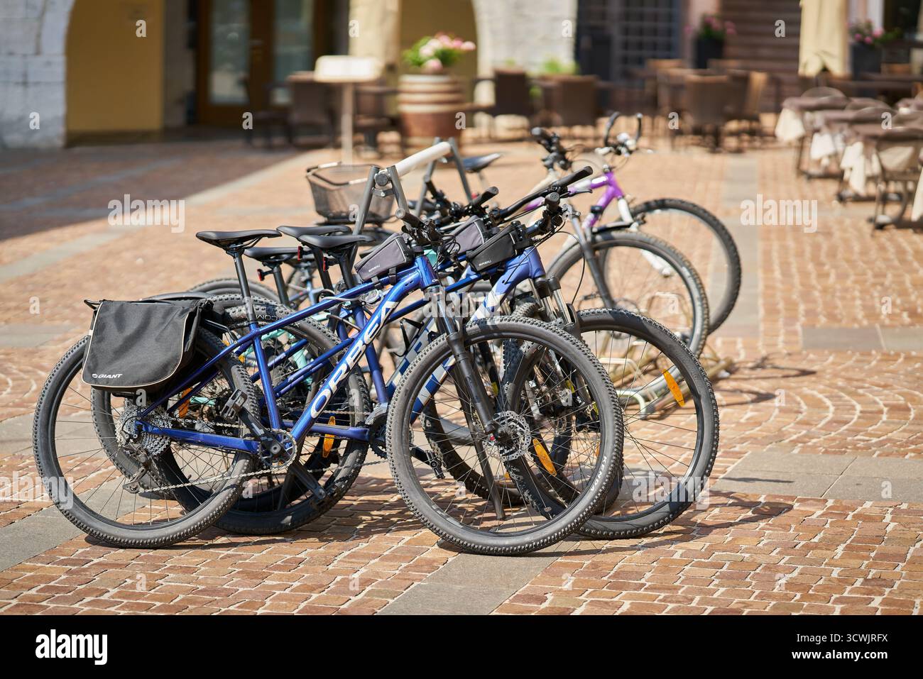 Vélos garés par les vacanciers devant un hôtel à Riva del Garda sur le lac de Garde en Italie Banque D'Images