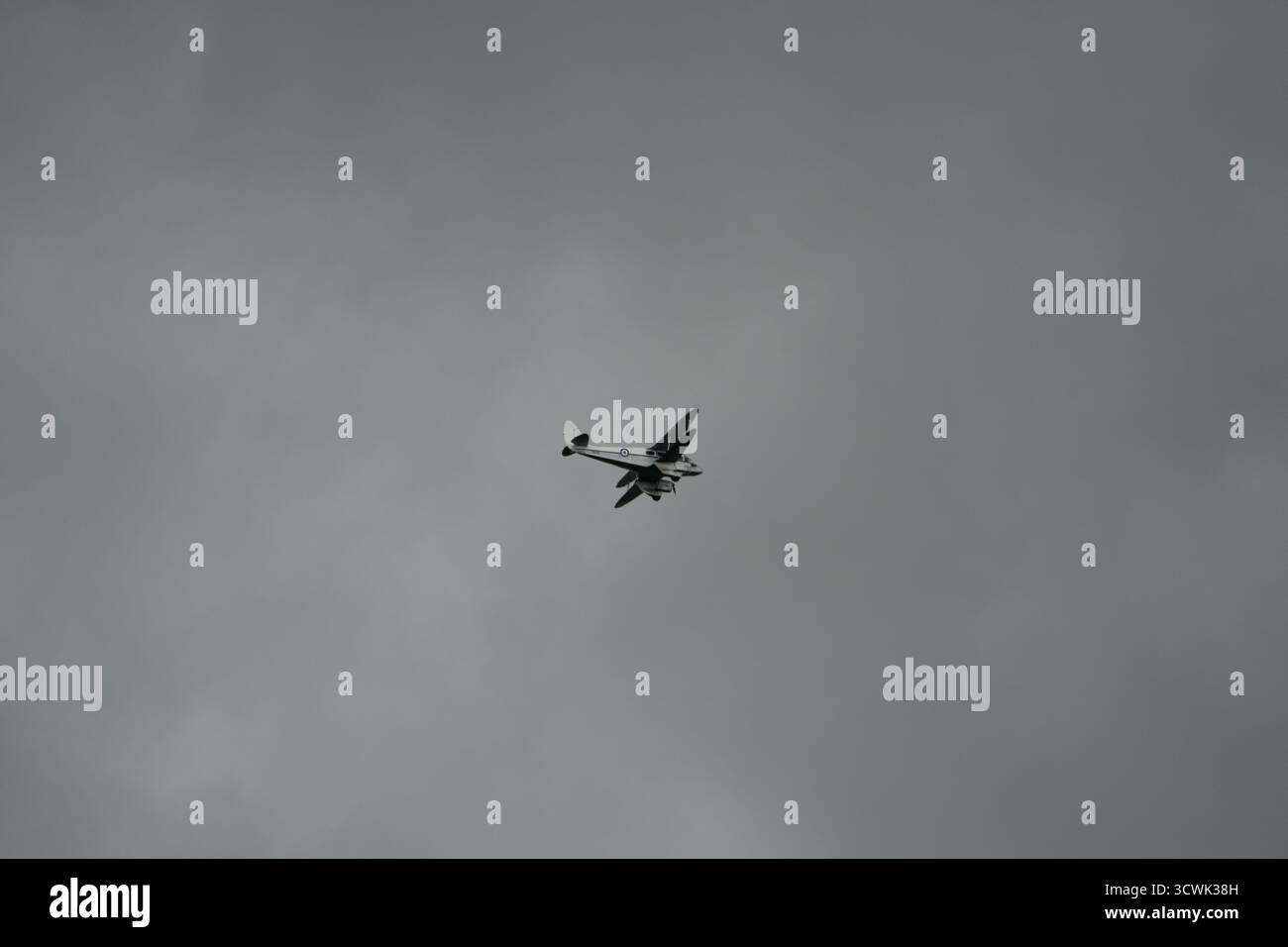 Un seul avion se silhouette contre un ciel gris couvert au spectacle aérien de Duxford Banque D'Images