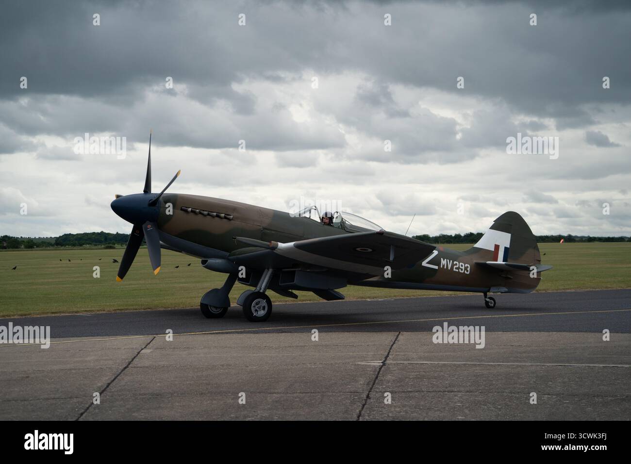 Supermarine Spitfire MV293 sur piste sous un ciel nuageux spectaculaire à l'aérodrome historique Banque D'Images