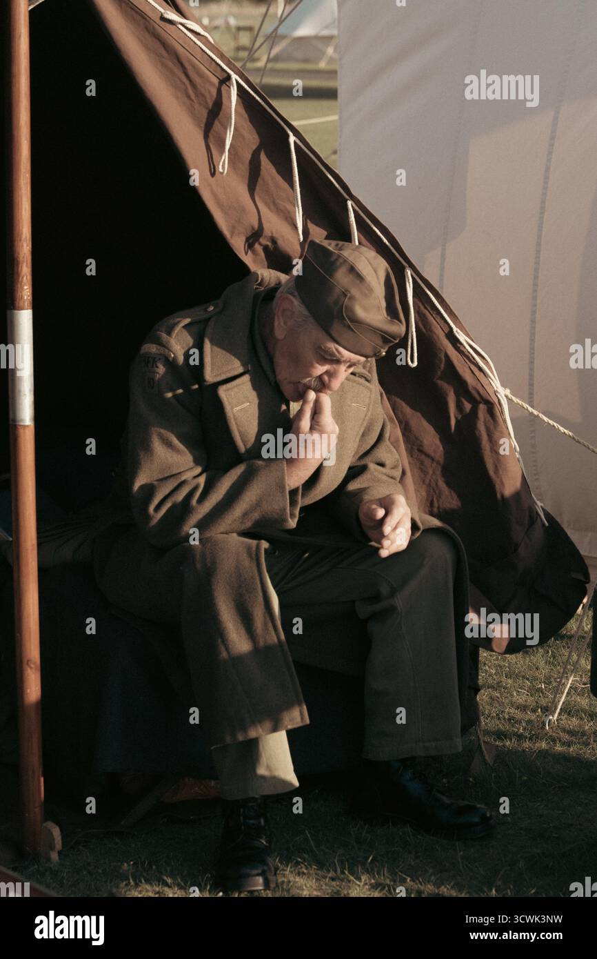 Le pilote de la RAF de la seconde Guerre mondiale en veste volante est assis pensivement dans une tente en toile au spectacle aérien de Duxford Banque D'Images
