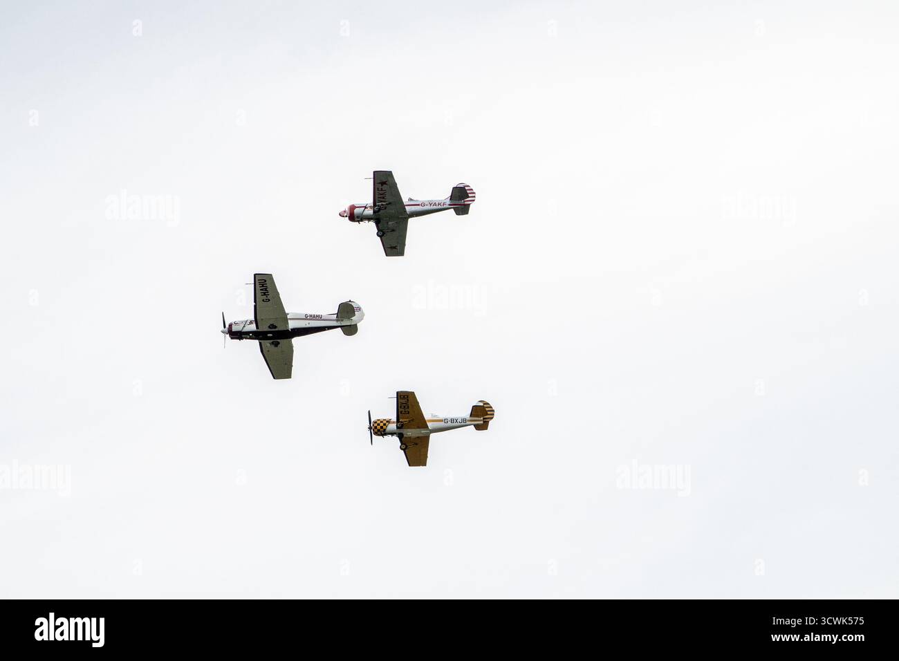 Trois avions vintage en vol en formation contre ciel couvert Banque D'Images